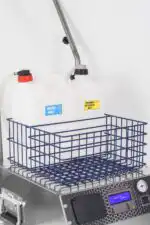 Metalna korpa leži na digitalnom displeju Paročistač Steam Italy 8000XL. Dva bijela vrča s natpisom Samo za vodu i Odobreni deterdžent imaju spojena crijeva.