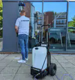 Obučen u belu majicu i farmerke, neko vešto čisti prozore Streamflo 25L koristeći dugačku motku i mobilni rezervoar za vodu.