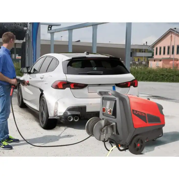 Osoba koristi crveno-sivi Biemmedue SUPREMA perač pod pritiskom (160-300 bara, 130°C) za pranje belog auta napolju.