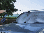 Osoba u crnoj rukavici koristi Profi mašinu za auto-detailing Biemmedue EX-F 80 i prska sapunicu po vetrobranu plavog Jeep SUV-a na suncu.