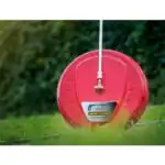 Površinski čistač ES400 (400 mm, 230bar) nalazi se na travi, spojen sa tlakovodnim štapom; u pozadini je živica.