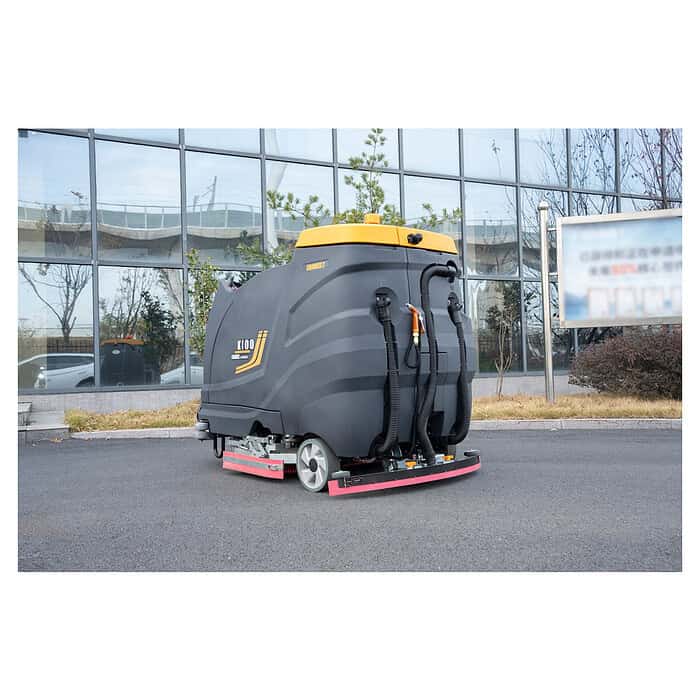 CHANCEE K100 podna mašina za čišćenje, crno-žuta, stoji na ploči pored staklene zgrade sa zelenilom.