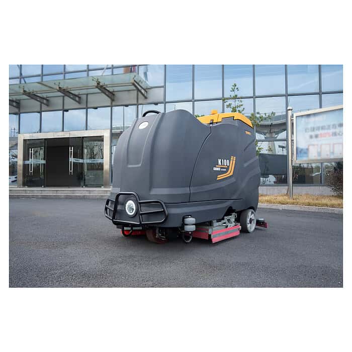 CHANCEE K100 siva i žuta mašina za pranje podova (36V, 5h, 3 god. garancije) stoji na ploči ispred staklene zgrade.