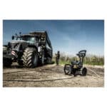 Osoba stoji pored crnog traktora i prikolice na zemljištu, a Annovi Reverberi AR5-15.23CT perač pod pritiskom je napred.